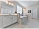 Bright bathroom with large mirrors, double sinks, a soaking tub, and neutral tile at 449 Carmichael Cir, Canton, GA 30115