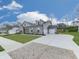 A brick and vinyl home with a large driveway leading to a two-car garage and well-manicured lawn at 449 Carmichael Cir, Canton, GA 30115