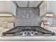 Close-up of a modern KitchenAid gas range stove top with white countertops and stylish gray backsplash at 449 Carmichael Cir, Canton, GA 30115