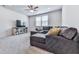 Bright living room features plush carpeting, ceiling fan, and comfortable seating with natural light from the window at 449 Carmichael Cir, Canton, GA 30115