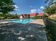 A pristine community pool with clear blue water, surrounded by lush trees and comfortable lounging areas at 449 Carmichael Cir, Canton, GA 30115