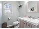 Cozy bathroom with a grey vanity, white sink, and decorative mirror at 904 Beaumont Ct, Canton, GA 30114
