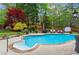 Backyard swimming pool with a lush green lawn, mature trees and lounge chairs at 904 Beaumont Ct, Canton, GA 30114