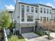 Beautiful three-story home with a gray brick facade, attached garage, and manicured landscaping at 1388 La France Ne St, Atlanta, GA 30307
