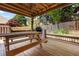 Outdoor back deck featuring a wooden table and a brick fireplace at 488 Takely Dr, Lawrenceville, GA 30046