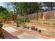 Landscaped backyard featuring a brick retaining wall and mature trees at 488 Takely Dr, Lawrenceville, GA 30046