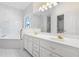 Bathroom with double vanity, garden tub, decorative glass window, and luxurious finishes at 488 Takely Dr, Lawrenceville, GA 30046