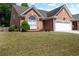 Brick home with manicured front yard and two-car garage at 488 Takely Dr, Lawrenceville, GA 30046