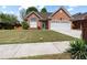 Charming brick home with a well-manicured lawn and attached two car garage at 488 Takely Dr, Lawrenceville, GA 30046