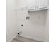 Bright laundry room features white cabinets, a wire shelf, and hookups for a washer and dryer at 488 Takely Dr, Lawrenceville, GA 30046