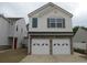 Two-story home featuring a two-car garage, a brick foundation, and light gray siding at 5815 Mountain Top Pl, Cumming, GA 30041