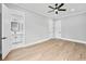 Bright bedroom featuring hardwood floors, ceiling fan, and ensuite bathroom entrance at 2107 E Maddox Rd, Buford, GA 30519