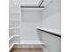 Walk-in closet showing custom white shelving and dark hardware for an organized storage system at 2107 E Maddox Rd, Buford, GA 30519