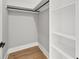 Walk-in closet with custom shelving, rod, and hardwood flooring at 2107 E Maddox Rd, Buford, GA 30519