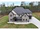 An aerial view of a charming two-story home featuring a brick facade and well-manicured lawn at 2107 E Maddox Rd, Buford, GA 30519