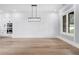 Elegant living room featuring decorative wall trim, wood floors, and modern light fixture at 2107 E Maddox Rd, Buford, GA 30519