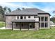 View of back of home, showing covered patio, brick exterior, and expansive windows at 2107 E Maddox Rd, Buford, GA 30519