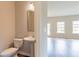 Stylish half bathroom featuring a pedestal sink and a neutral color scheme, conveniently located near the living area at 2396 Bear Mountain St, Lithonia, GA 30058