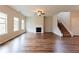 Open living room boasts hardwood floors, fireplace, ceiling fan, and staircase at 2396 Bear Mountain St, Lithonia, GA 30058