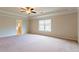 Spacious main bedroom with tray ceiling, ceiling fan, and large window at 2396 Bear Mountain St, Lithonia, GA 30058