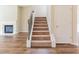 Carpeted staircase with decorative iron railings, leading to the upper level, adjacent to a cozy fireplace at 2396 Bear Mountain St, Lithonia, GA 30058
