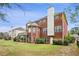 Backyard with green grass and updated red-brick house with a white chimney at 295 Langshire Dr, Mcdonough, GA 30253