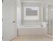 Bathroom featuring a soaking tub with tile surround and a glass-enclosed shower at 295 Langshire Dr, Mcdonough, GA 30253