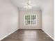 Bedroom with neutral paint, hardwood floors, ceiling fan, and large window at 295 Langshire Dr, Mcdonough, GA 30253