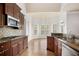 Kitchen features wood cabinets, stainless steel appliances, granite countertops, tile backsplash, and hardwood floors at 295 Langshire Dr, Mcdonough, GA 30253