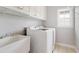 Laundry room features white cabinets, sink, and front loading washer and dryer at 295 Langshire Dr, Mcdonough, GA 30253