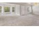 Open-concept living room with plush carpeting and several windows providing natural light at 295 Langshire Dr, Mcdonough, GA 30253