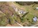 Gorgeous aerial view of a modern home, barn, and shed on a sprawling lot bordered with mature trees and lush landscaping at 111 Ayers Driver Rd, Villa Rica, GA 30180