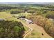 Expansive aerial view of the property showcasing the home, barn, and surrounding landscape with mature trees at 111 Ayers Driver Rd, Villa Rica, GA 30180