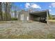 Metal barn with a lean-to, concrete pad, and gravel for parking and storage at 111 Ayers Driver Rd, Villa Rica, GA 30180