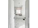 Bathroom featuring a large tub, marble tile, and natural light at 1166 Farmstead Rd, Suwanee, GA 30024