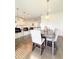 Dining area featuring a modern light fixture, hardwood floors, and a view of the kitchen at 1166 Farmstead Rd, Suwanee, GA 30024