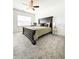 Bright main bedroom features neutral carpet, a ceiling fan, and a large window at 1166 Farmstead Rd, Suwanee, GA 30024