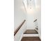 Bright staircase with dark wood treads, white risers, and an elegant light fixture at 1166 Farmstead Rd, Suwanee, GA 30024