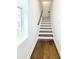 A staircase featuring hardwood steps, and a large window for ample natural light at 1166 Farmstead Rd, Suwanee, GA 30024