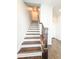 Elegant staircase with hardwood treads, white risers, and dark railing at 1166 Farmstead Rd, Suwanee, GA 30024