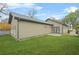 Backyard view of a home with tan siding, a walk-out patio, and a grassy area at 1716 Browning Sw St, Atlanta, GA 30314