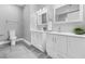 Bright bathroom featuring double vanity, matching mirrors and soft gray tile floor at 1716 Browning Sw St, Atlanta, GA 30314