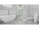 Bathroom featuring soaking tub, walk-in glass shower and soft gray tiled flooring at 1716 Browning Sw St, Atlanta, GA 30314