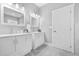 Bright bathroom featuring double vanity, matching mirrors and soft gray tile floor at 1716 Browning Sw St, Atlanta, GA 30314