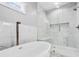 Bathroom featuring soaking tub and walk-in glass shower with tiled accent wall at 1716 Browning Sw St, Atlanta, GA 30314