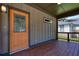 Covered front porch featuring a stained wood floor, wood-paneled siding, a decorative door, and a partial view of the street at 1716 Browning Sw St, Atlanta, GA 30314