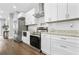 This bright kitchen features white cabinets, granite countertops, stainless steel appliances, and backsplash at 1716 Browning Sw St, Atlanta, GA 30314
