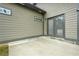 Concrete patio leads to a house with tan siding, a double door entry, and a security camera at 1716 Browning Sw St, Atlanta, GA 30314