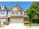 Charming townhouse with a two-car garage, manicured lawn, and inviting curb appeal at 2436 Sardis Chase Ct, Buford, GA 30519