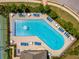 Aerial view of the community pool surrounded by lounge chairs, tables, and mature trees at 2436 Sardis Chase Ct, Buford, GA 30519